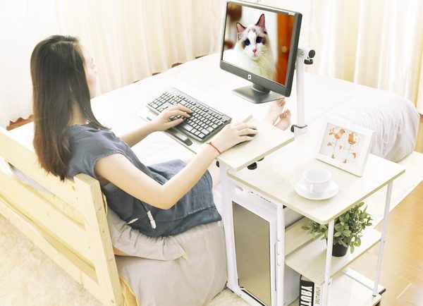 une table de chevet dans la chambre avec un ordinateur