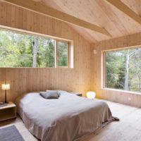 spavaća soba u drvenoj kući s prozorima
