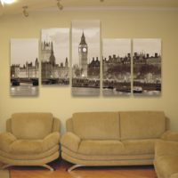 Black and white photo of five paintings over the sofa