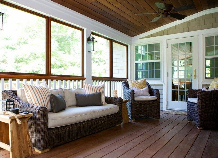 Rattan furniture with soft pillows on the summer terrace