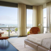 Panoramic windows of the living room with cream curtains