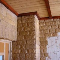 The combination of stone, wallpaper and wood in the decoration of the hallway