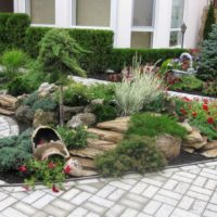 Stones and an old vase on a garden flower bed