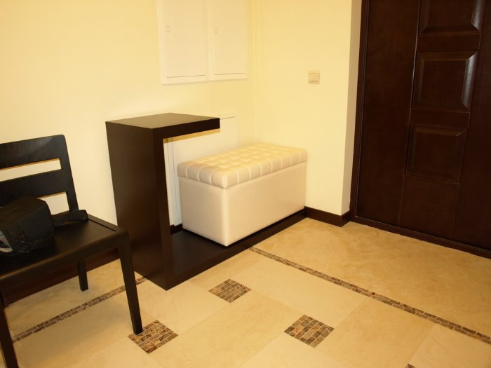 Cream ottoman and black counter in the hallway