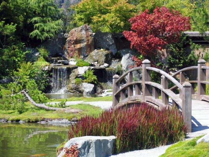 Cascata di pietra e ponte di legno in giardino cinese