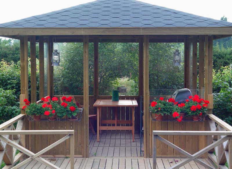 Décorer un gazebo en bois avec des fleurs dans des conteneurs