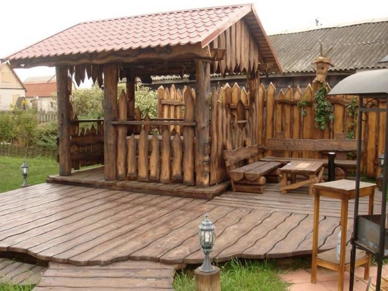 Gazebo in legno in stile country con una piattaforma fatta di assi di larice