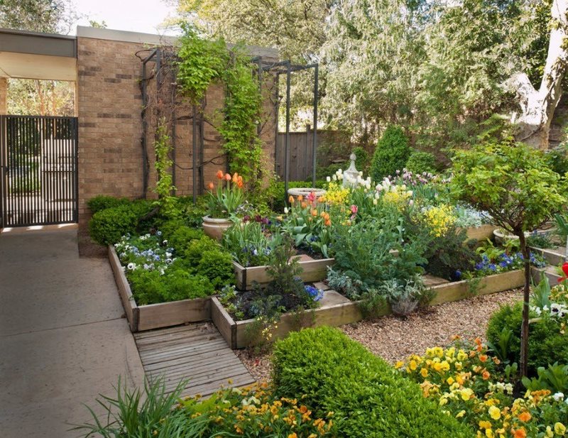 Tall flowerbeds from planed boards in the yard of a summer cottage