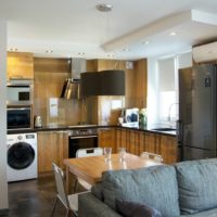 Dark gray fridge and wood furniture in a studio apartment