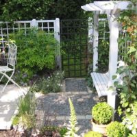 Pergola with a bench in front of the entrance to the garden