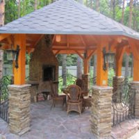 Wooden arbor on pillars made of flat stone