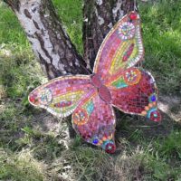 Plywood butterfly under birch trunks