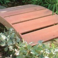 Simple wooden bridge over a garden creek