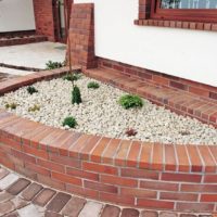 Flowerbed in front of a front brick house