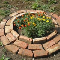 Parterre de fleurs rond pour soucis en vieille brique rouge