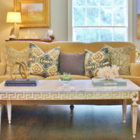 A table with carved legs in front of a sofa in the living room