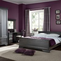 Murs lilas sombres et lit gris