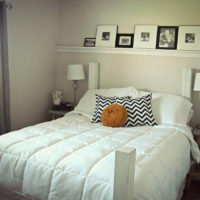 Shelf with paintings over the head of the bed