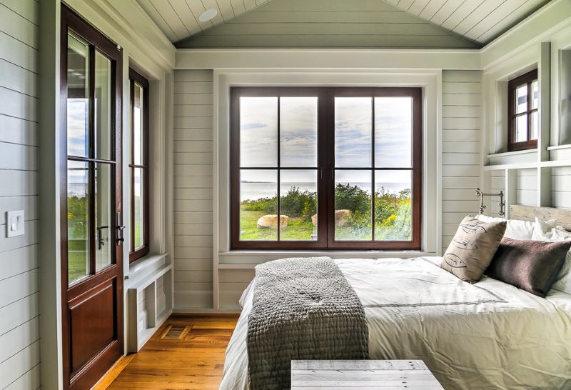 The interior of the bedroom of a country house with wall decoration painted lining