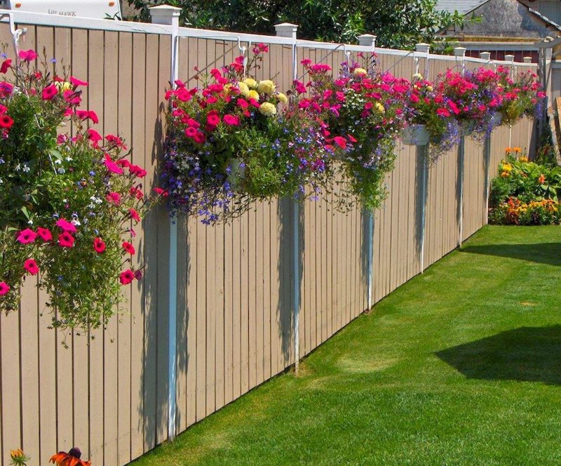 Décoration d'une clôture de pays d'un cache-pot avec des fleurs