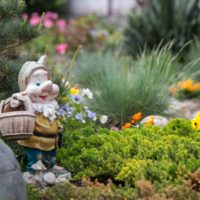 Bajkoviti gnome na cvjetnom vrtu vrtne parcele