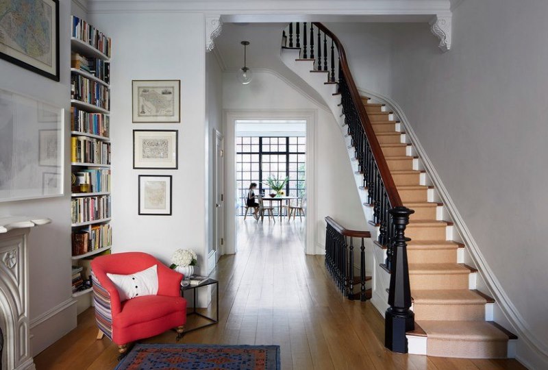 Bel escalier avec tapis et balustrade noire.