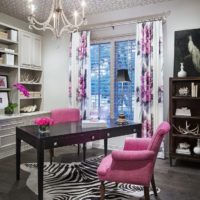 Armchair with pink upholstery in front of a black table