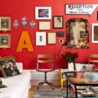 Pismo i slike na crvenom zidu dnevne sobe