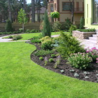 Parterre de fleurs devant une maison avec des fleurs et des arbustes