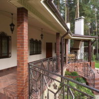 Outdoor terrace with brick pillars and wrought iron fencing