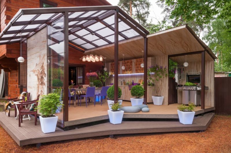 Terrasse avec verrière devant l'entrée d'un immeuble résidentiel