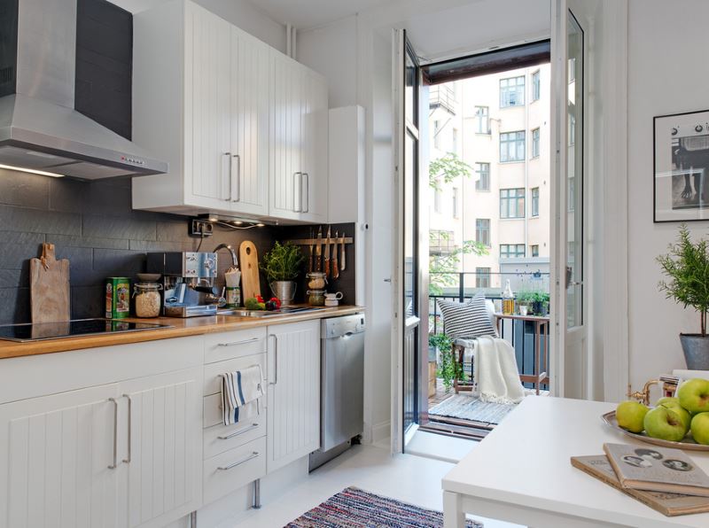 Kitchen design with white set and door to the balcony