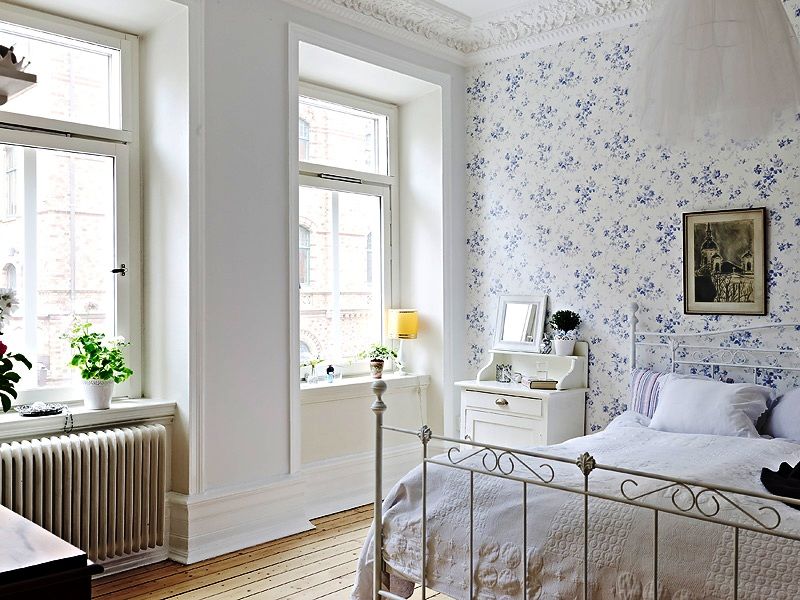 Decoration of the wall in the bedroom with wallpaper in a small flower