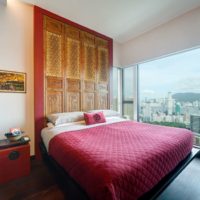 Red bedspread in a bed in a bedroom of a multi-storey building