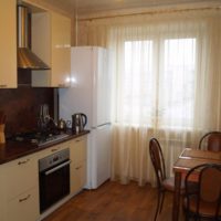 White two-chamber refrigerator at the kitchen window