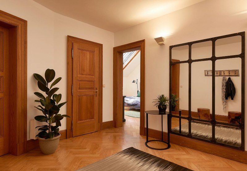 Hall d'entrée d'une maison privée avec sol marron et portes en bois