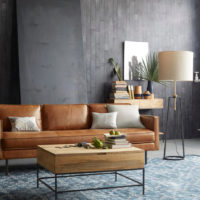 Brown sofa in the interior of the room with gray walls