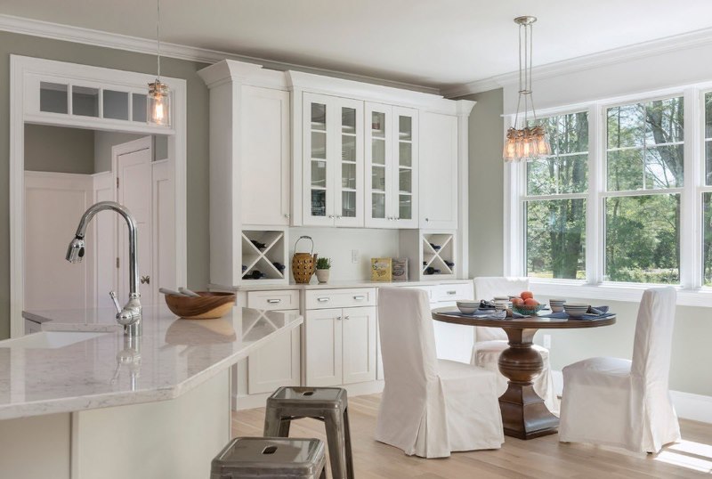 Dining area in the kitchen of the country house in front of the garden windows