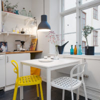 Žuta stolica u bijeloj kuhinji