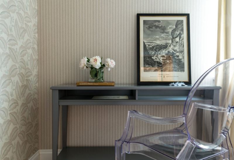 Fresh flowers on a table near a gray wall with wallpaper