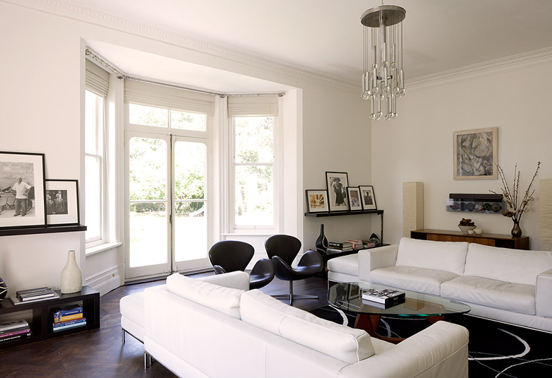 Interior of a beautiful living room in white with windows to the floor