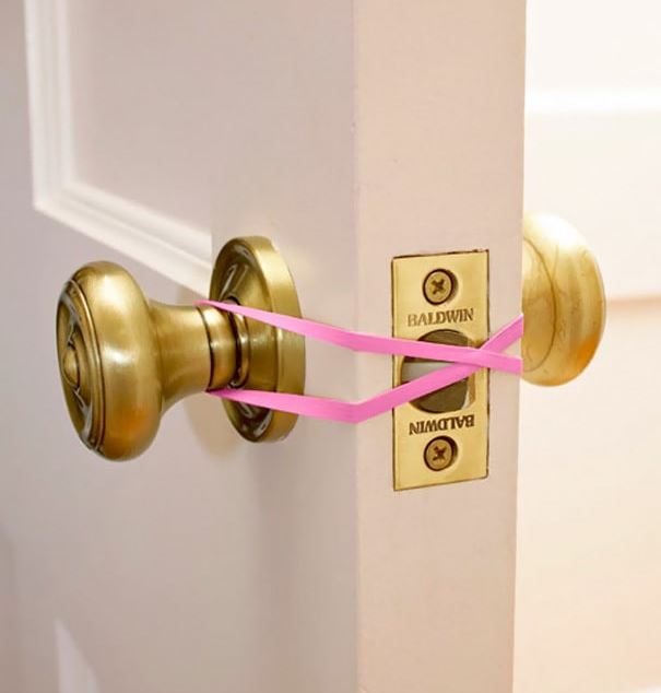 Life hack for home - une bande élastique servant de loquet pour un loquet de porte