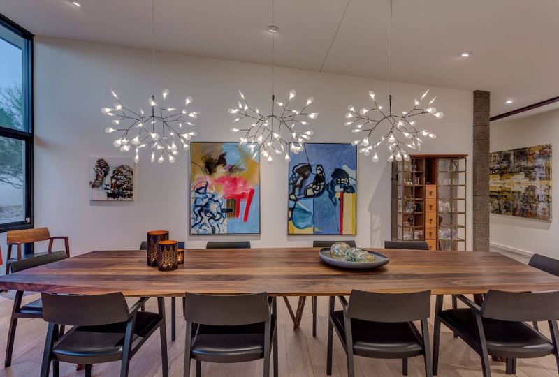 Living room interior of a country house with three chandeliers over a wooden table