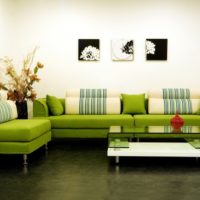 Zelena sofa u sobi s bijelim zidovima