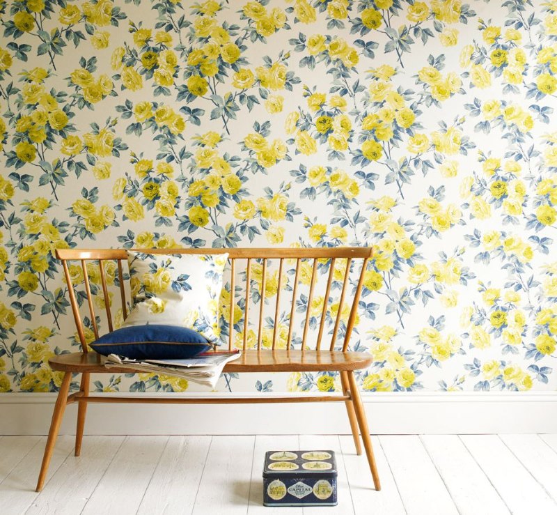 Papier peint avec des fleurs jaunes sur le mur du salon d'une maison de campagne