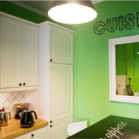 Ogledalo na zelenom zidu kuhinje