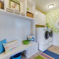 Two washing machines in the corner of the room