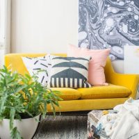 Gray rug in front of a yellow sofa