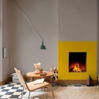 Gray wall and fireplace in the interior of the hall of a private house