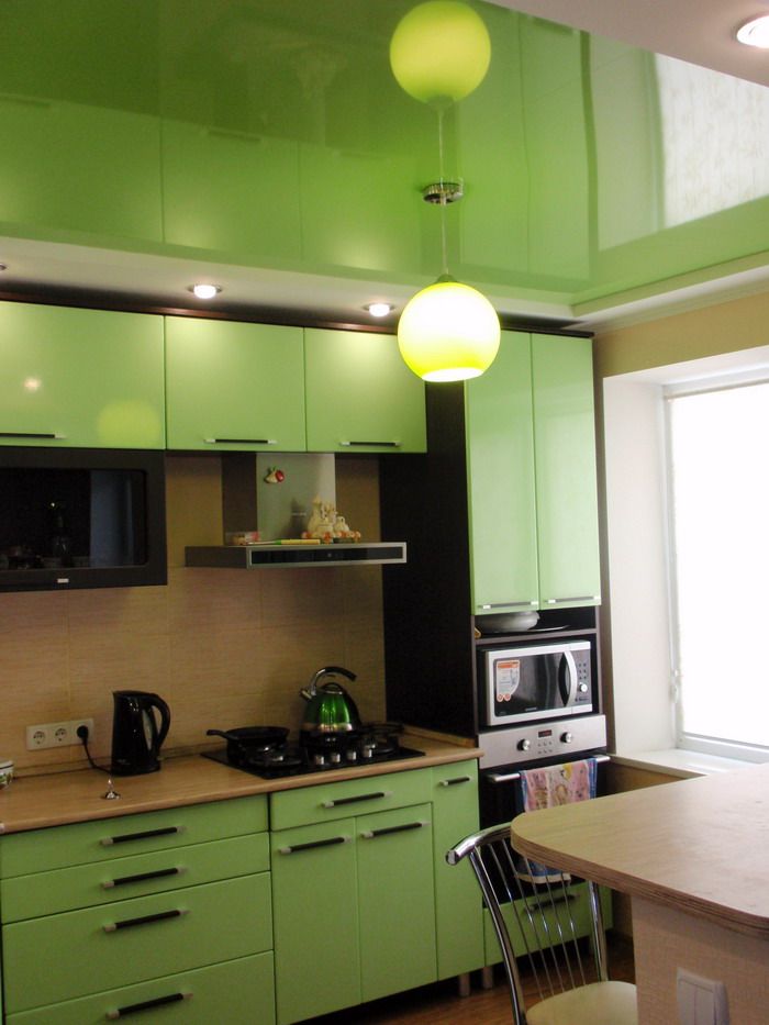 Mirror suspended ceiling in the kitchen with a green set